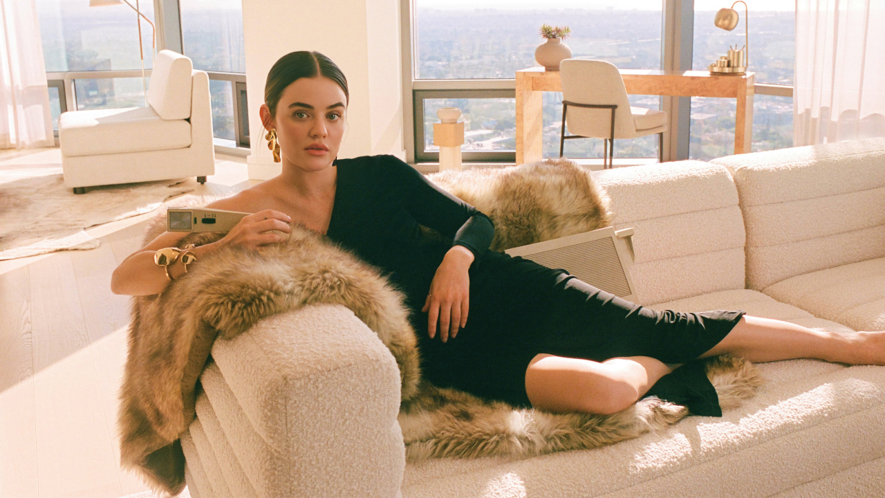 Актриса Люси Хейл в черном платье лежит на диване