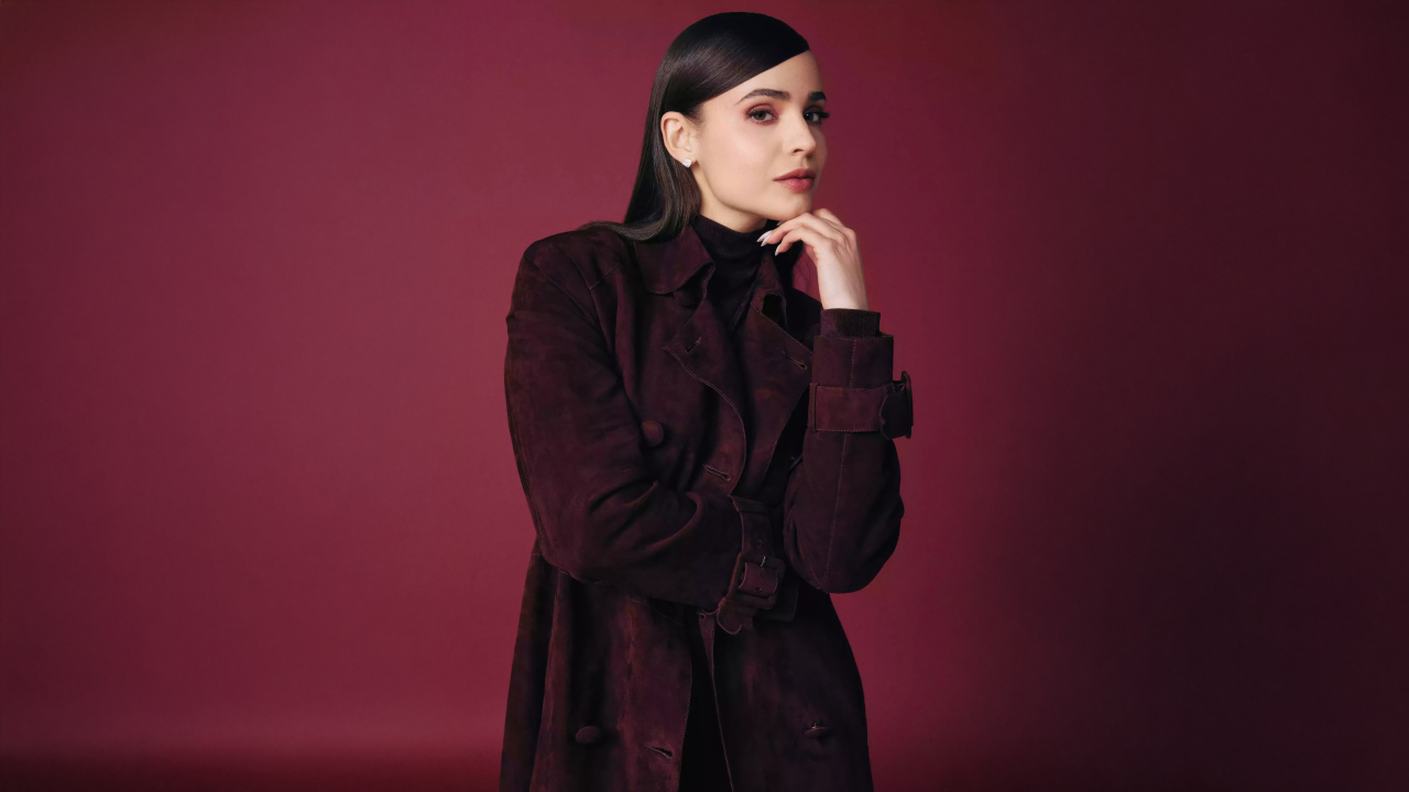 Актриса София Карсон в пальто на бордовом фоне
