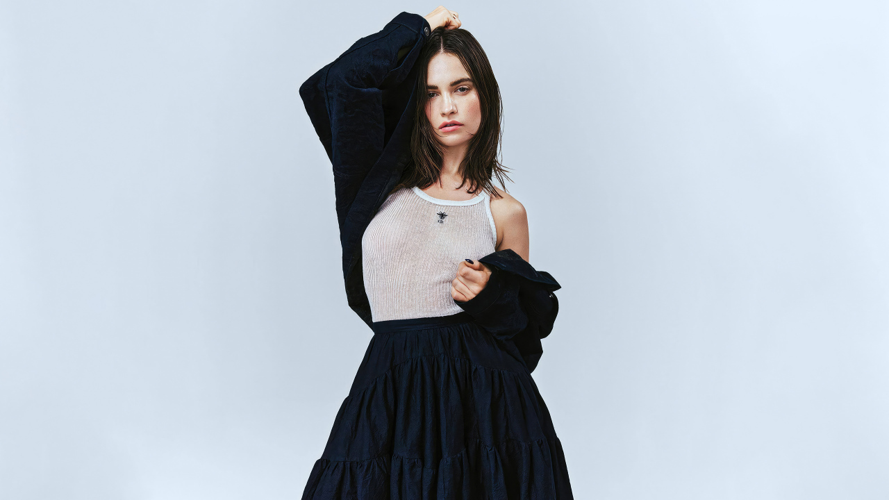 Красивая актриса Лили Джеймс стоит у стены