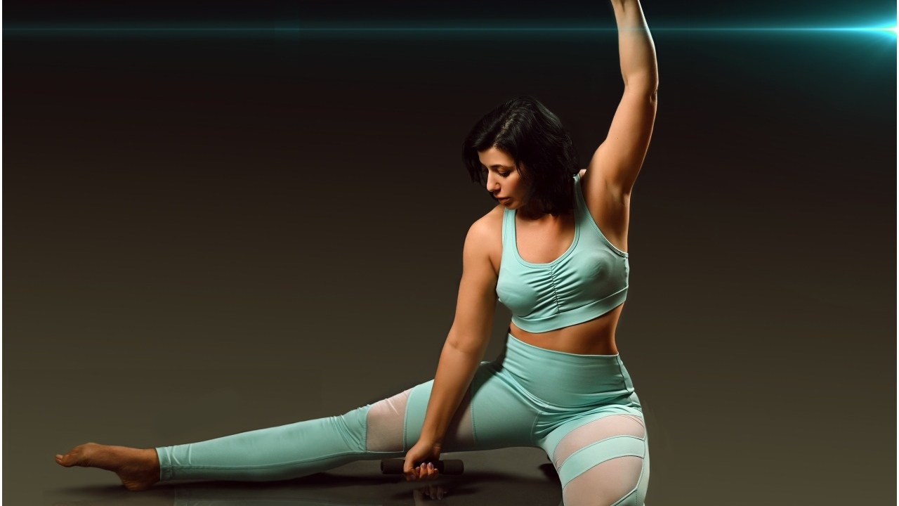 Девушка занимается фитнесом с гантелями