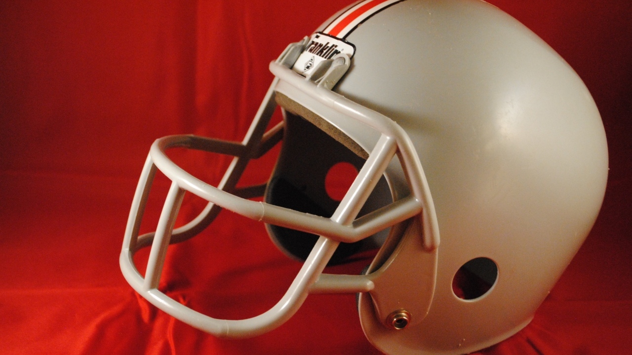 Шлем для игры в американский футбол на красном фоне