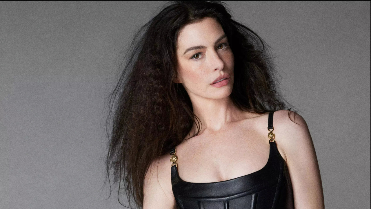 Длинноволосая актриса Энн Хэтэуэй на сером фоне