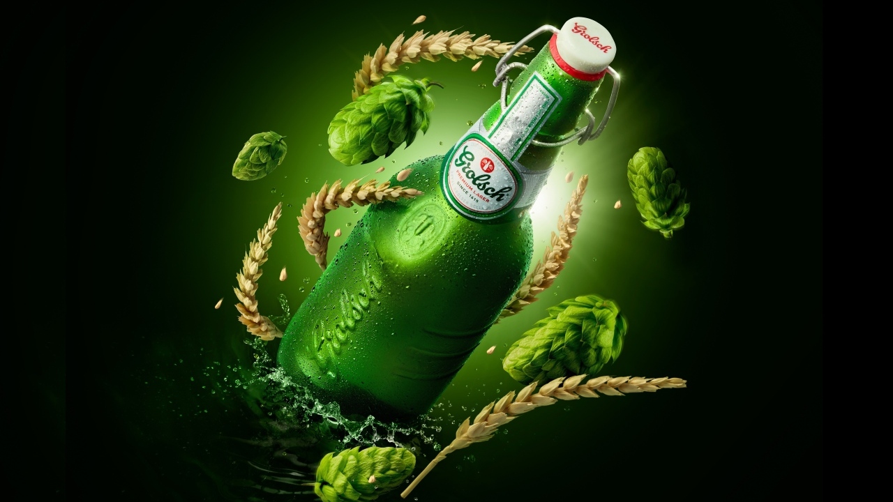 Зеленая бутылка с хмелем и пшеницей на черном фоне