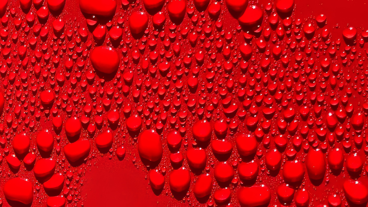 Капли воды на ярком красном фоне