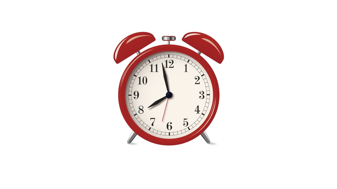 Красный будильник на белом фоне