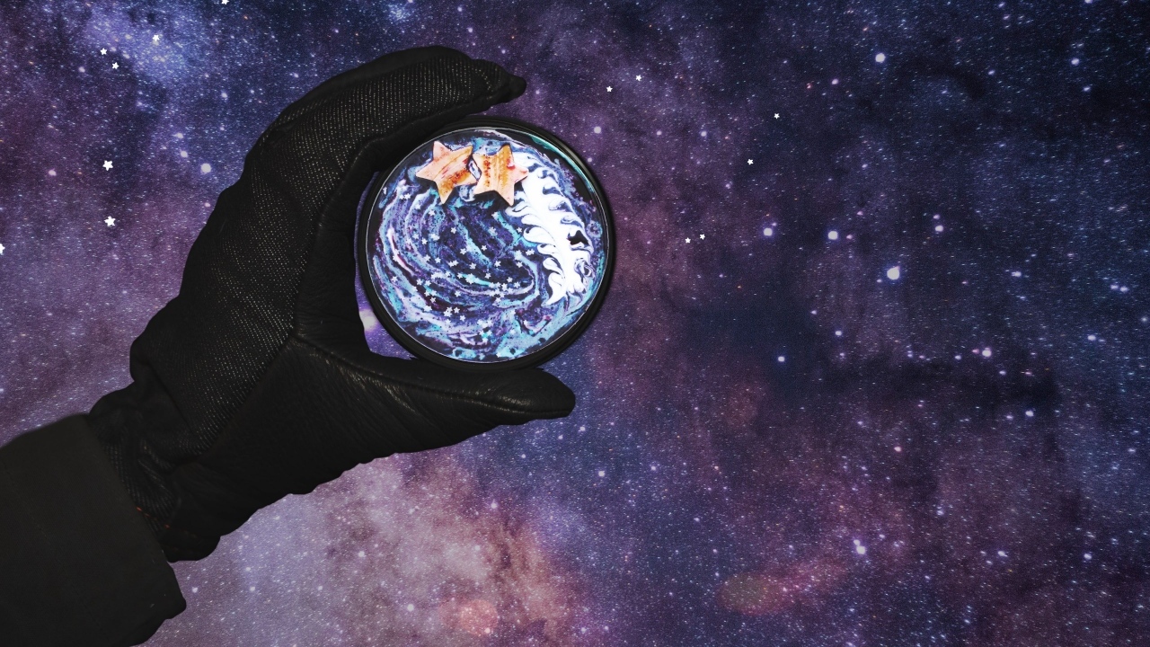 Рука в черной перчатке на фоне звездного неба