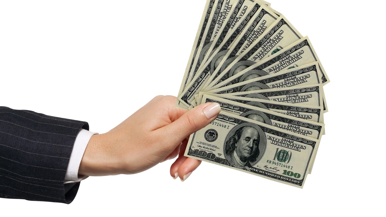 Пачка денег в руке на белом фоне