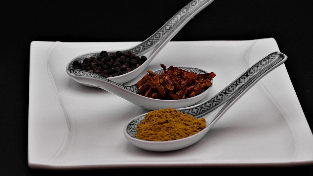 Ароматные специи в ложках на белой тарелке