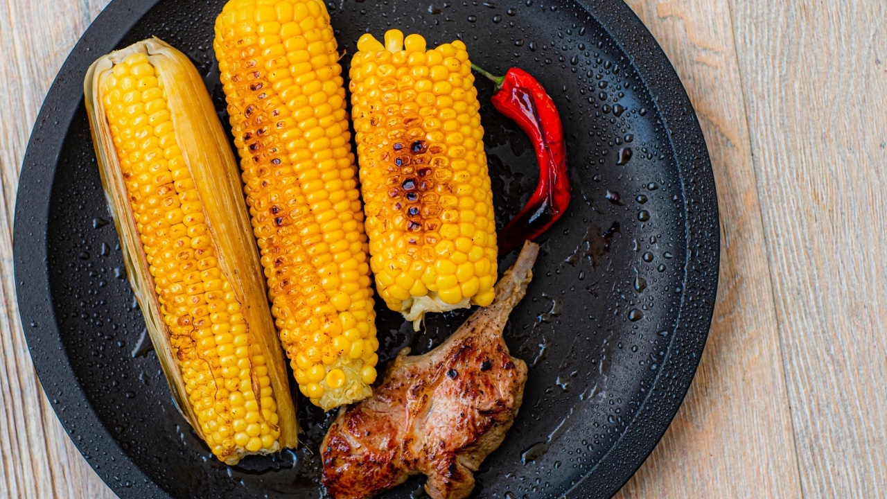 Запеченная кукуруза с ребрышками на тарелке