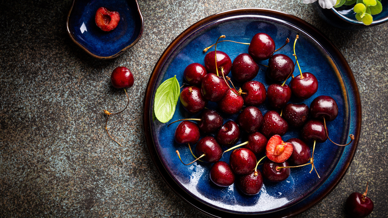 Синяя тарелка с красными ягодами черешни 