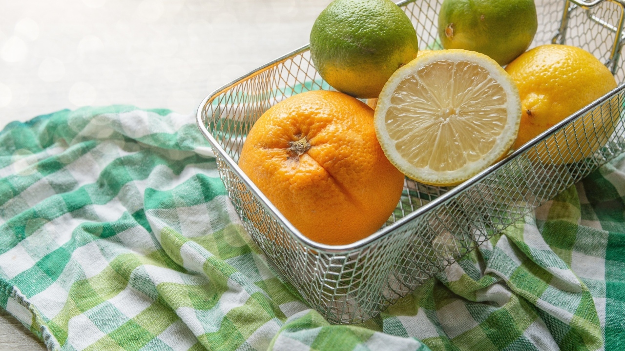 Цитрусовые фрукты в железной корзине на столе