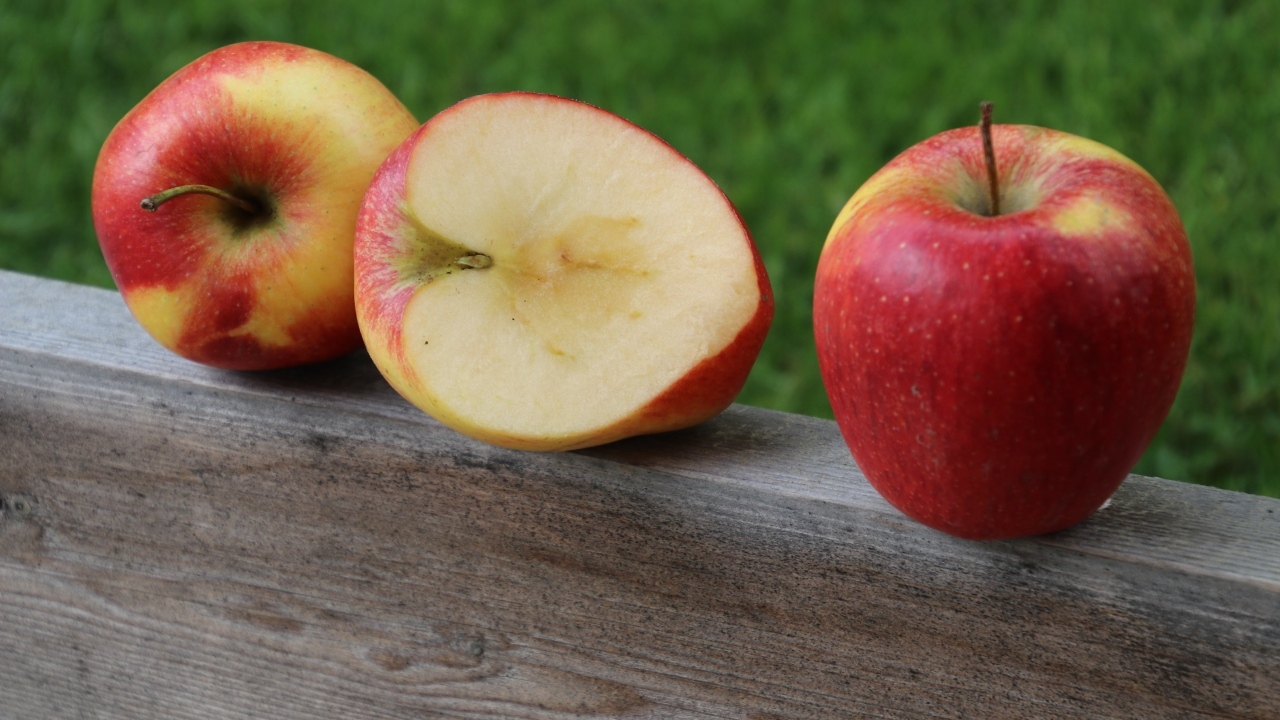 Красные яблоки лежат на деревянной доске