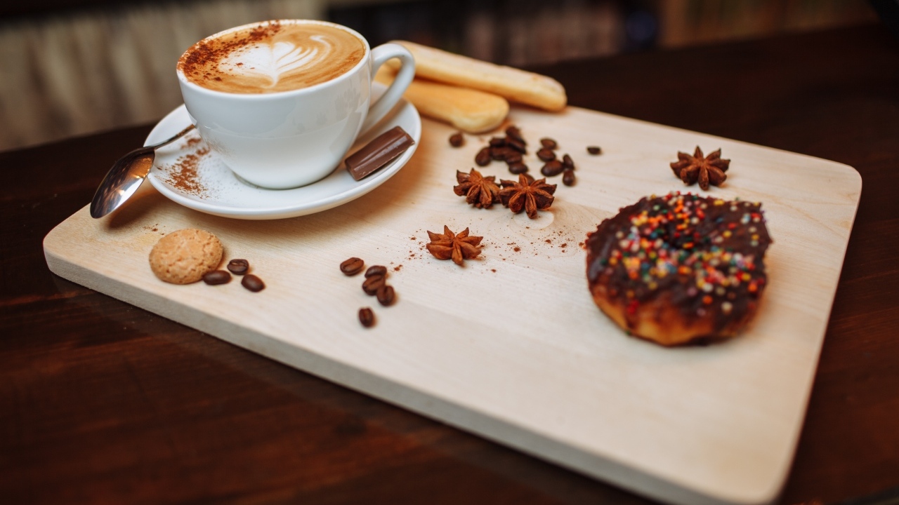 Чашка кофе на доске со специями и печеньем