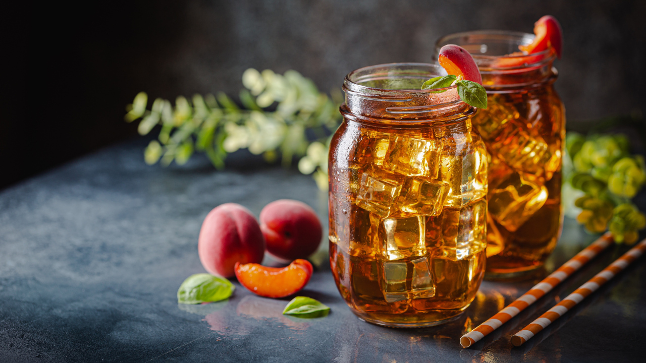 Холодный чай со льдом на столе с абрикосами