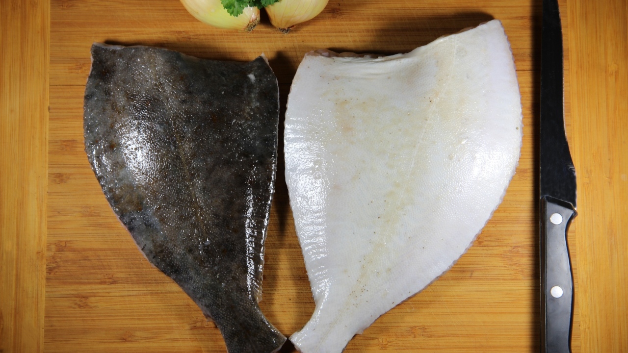 Камбала на доске с луком и ножом