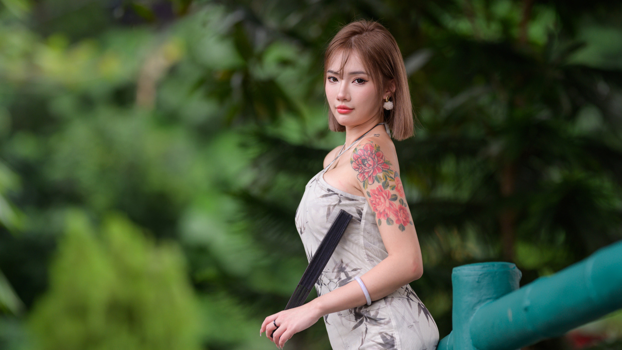 Красивая девушка азиатка с татуировкой на руке