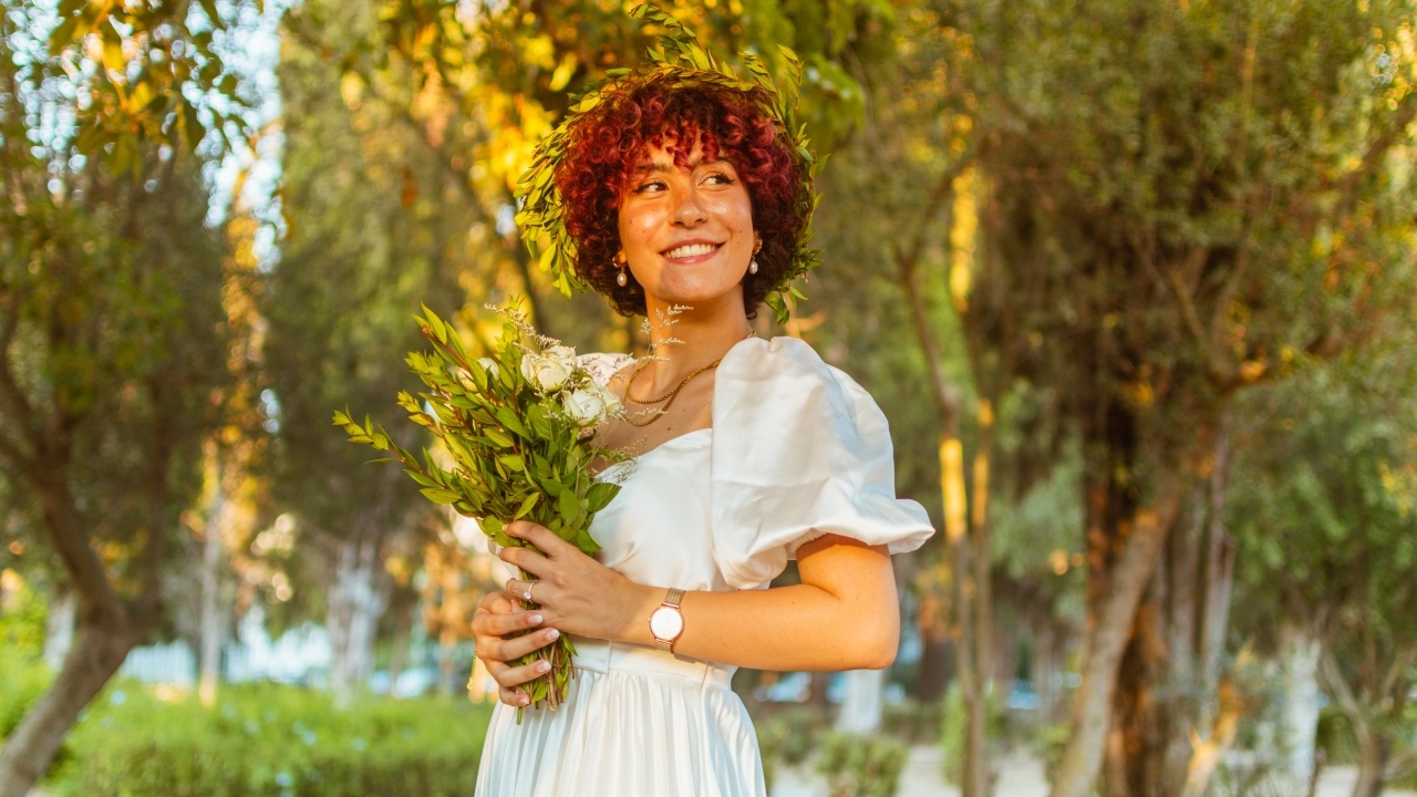 Красивая улыбающаяся рыжеволосая девушка с букетом