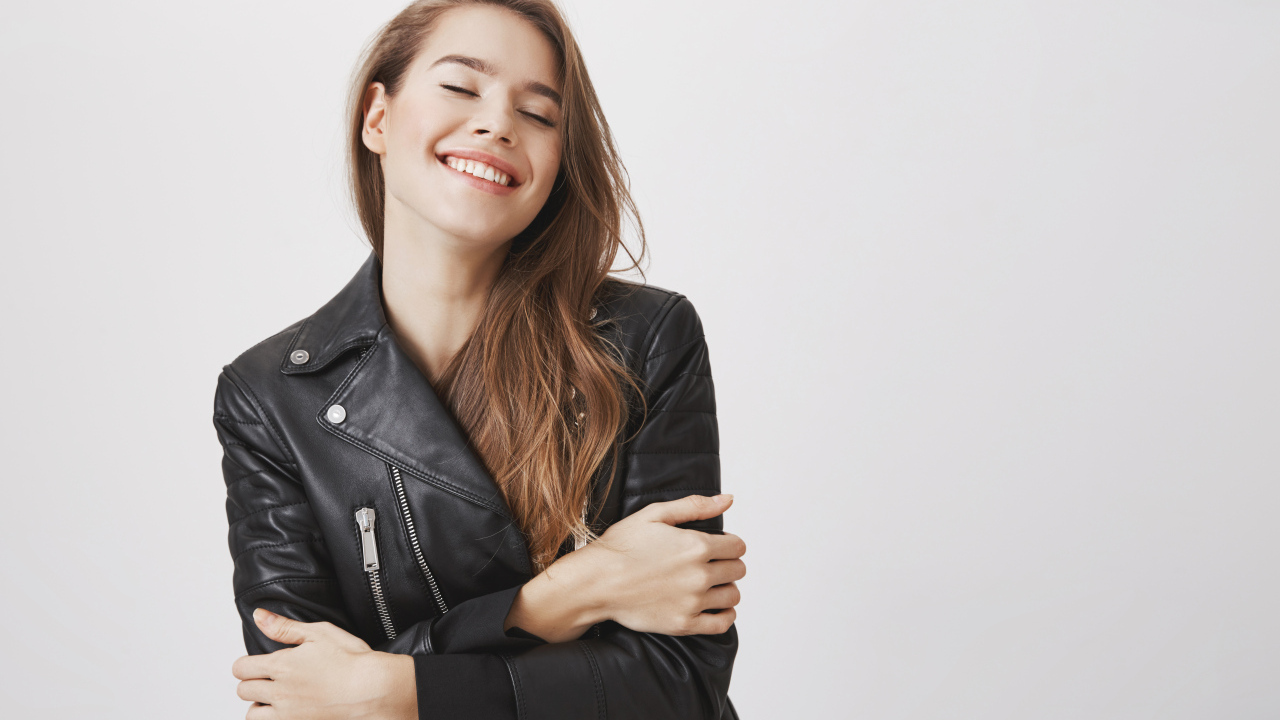 Девушка в черной кожаной куртке с закрытыми глазами