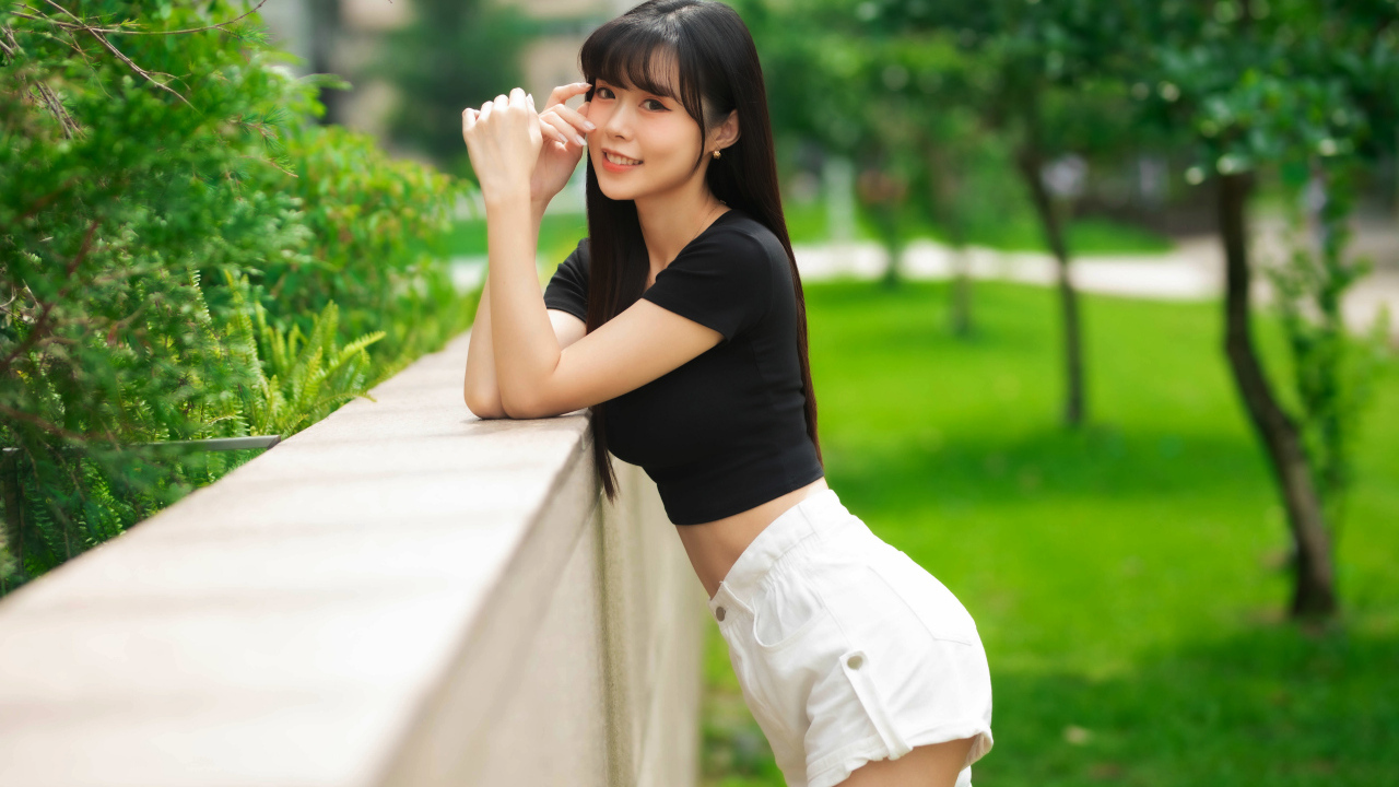 Молодая азиатка в белых шортах и футболке