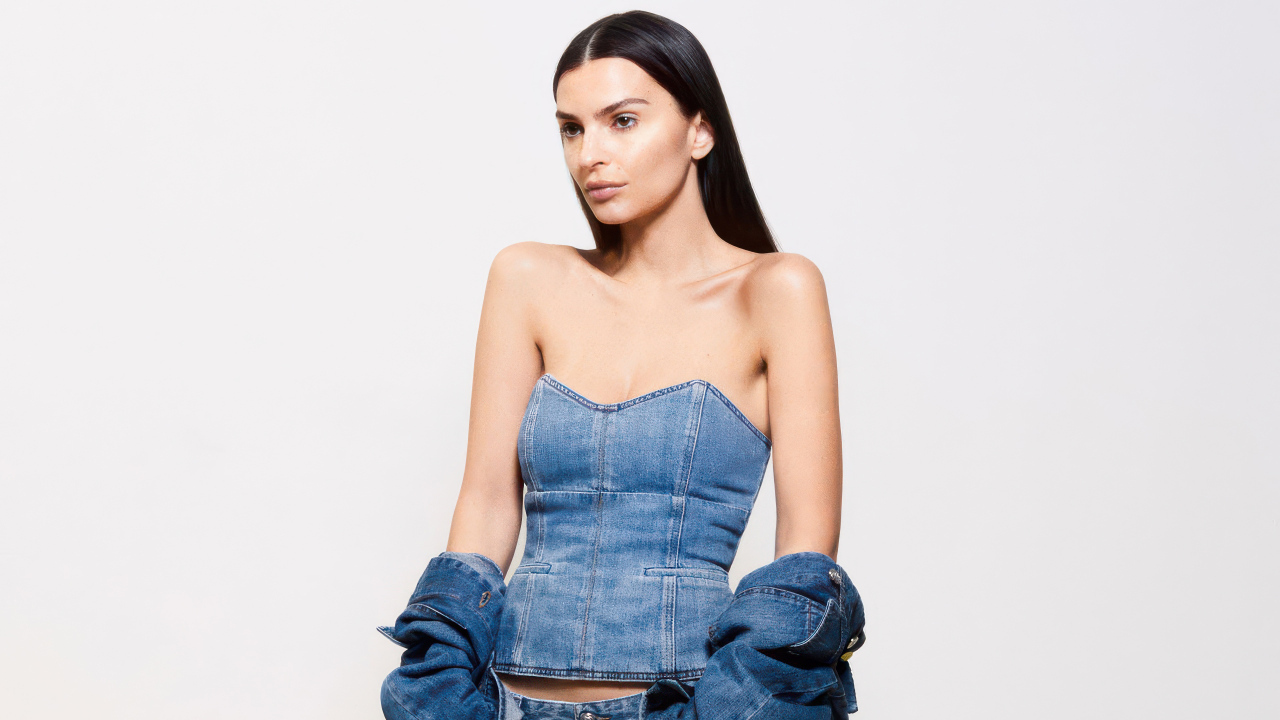 Модель Эмили Ратаковски в джинсовом костюме на белом фоне