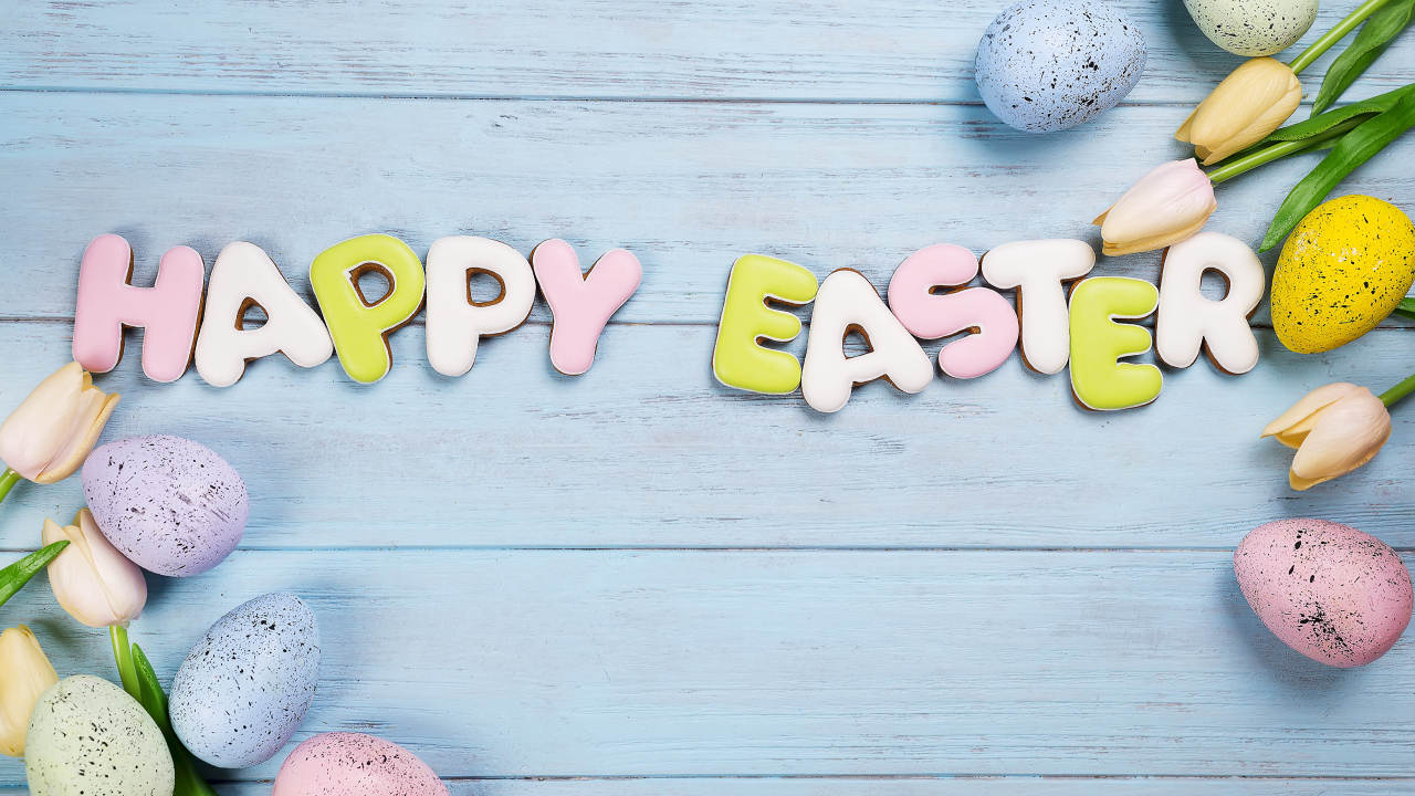 Печенье с надписью счастливой Пасхи с яйцами и цветами