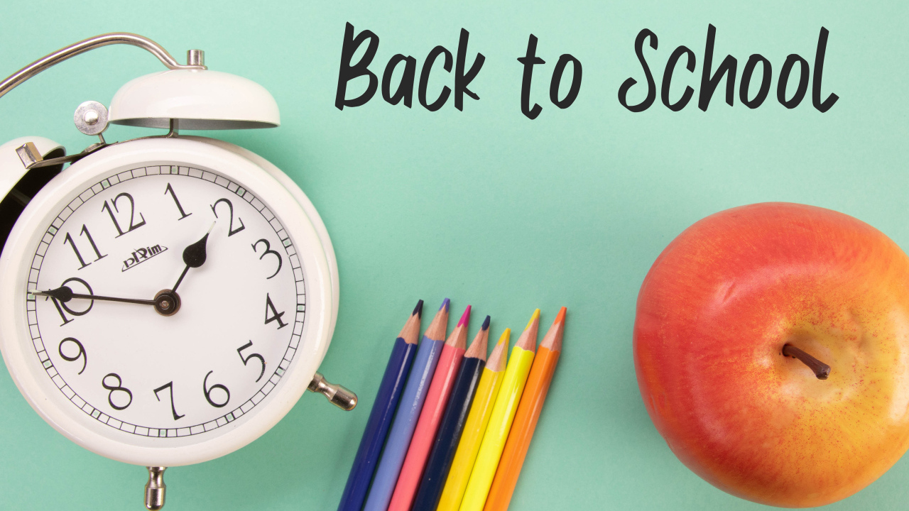 Будильник, карандаши и яблоко на фоне с надписью пора в школу