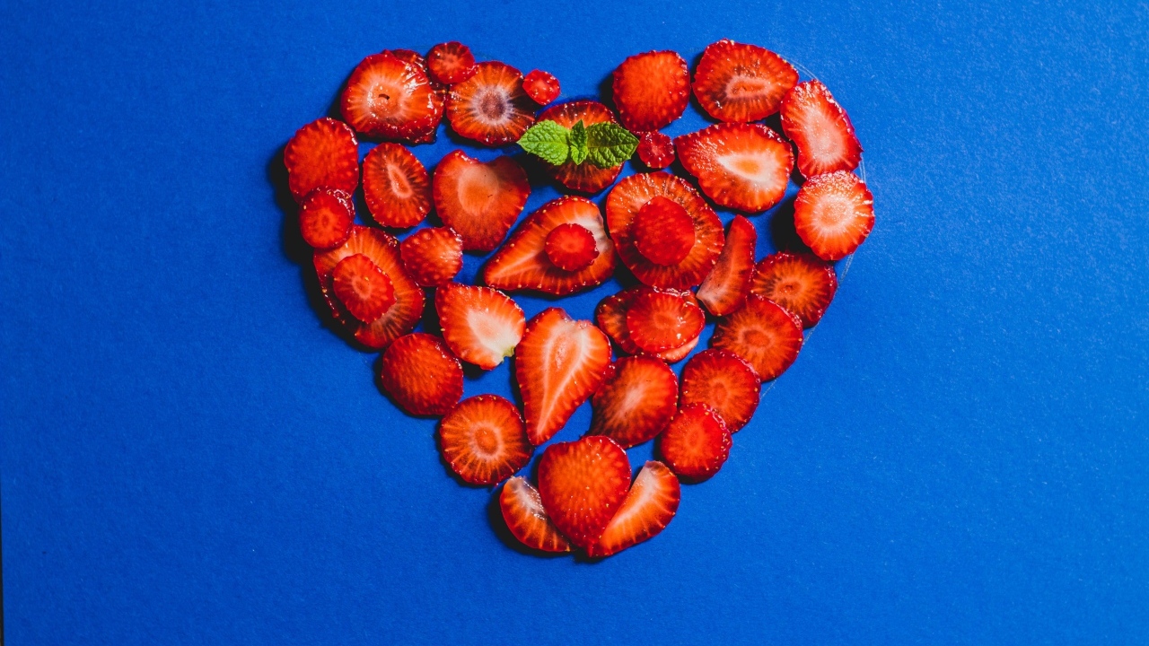 Сердце из сушеной клубники на синем фоне