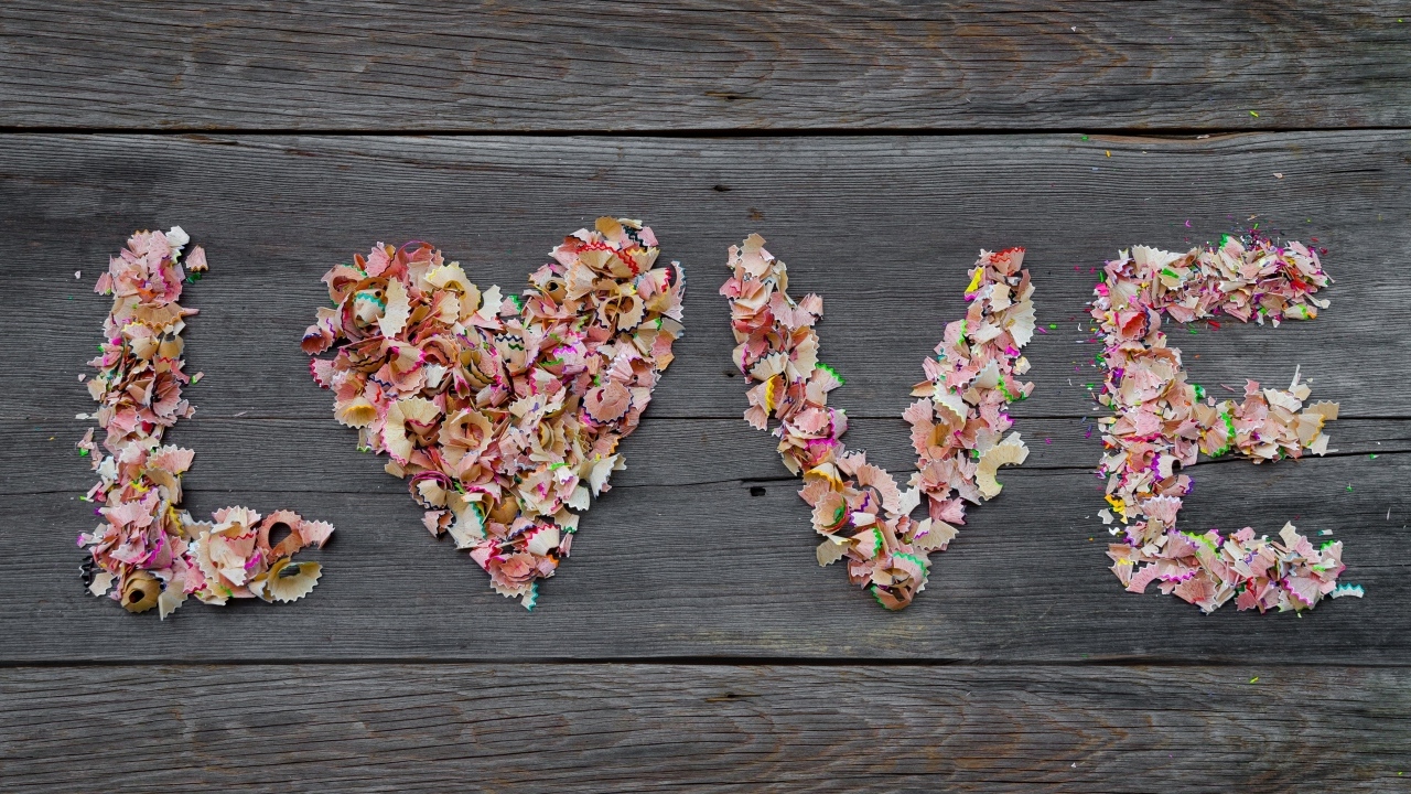 Надпись любовь из стружки карандашей на деревянном фоне