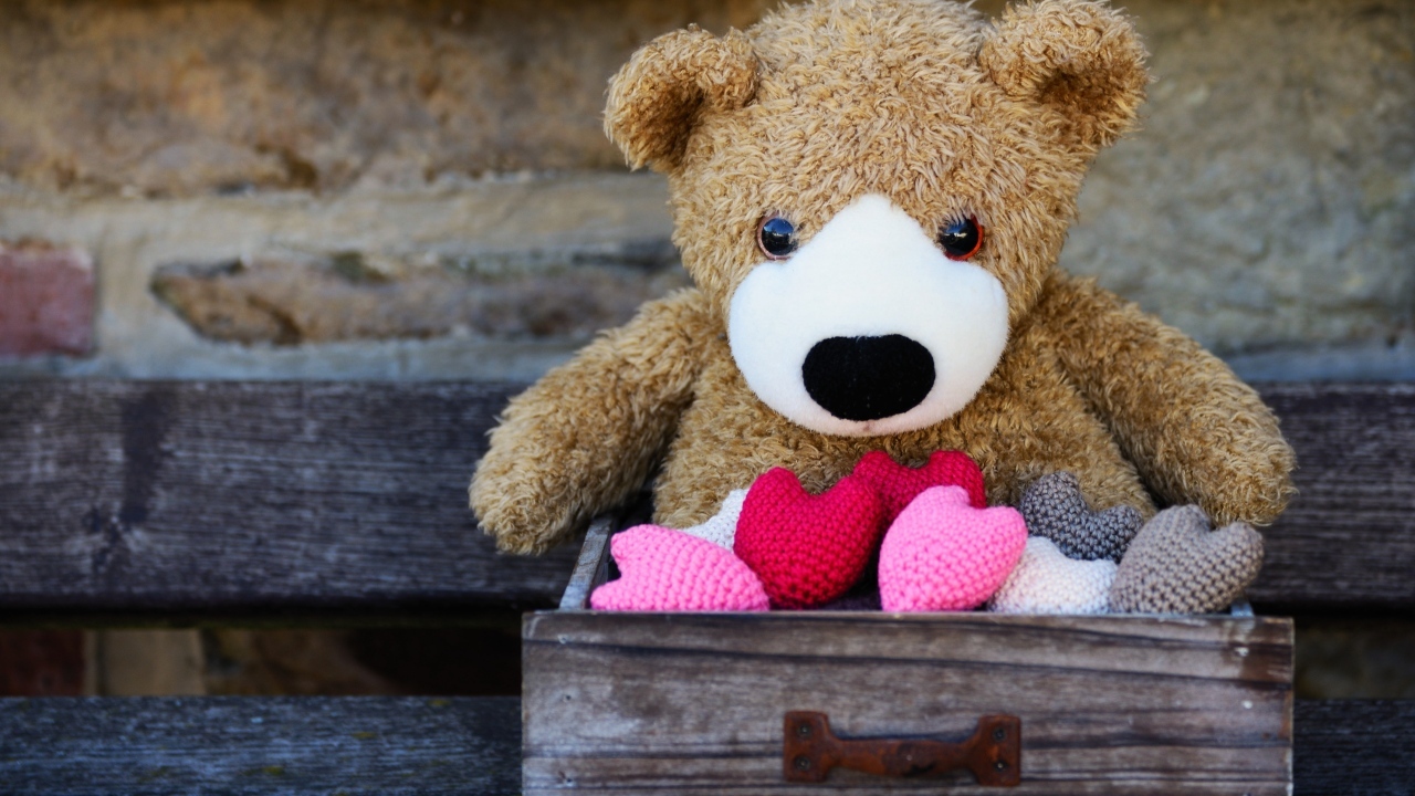 Игрушечный медвежонок с сердечками в деревянном ящике