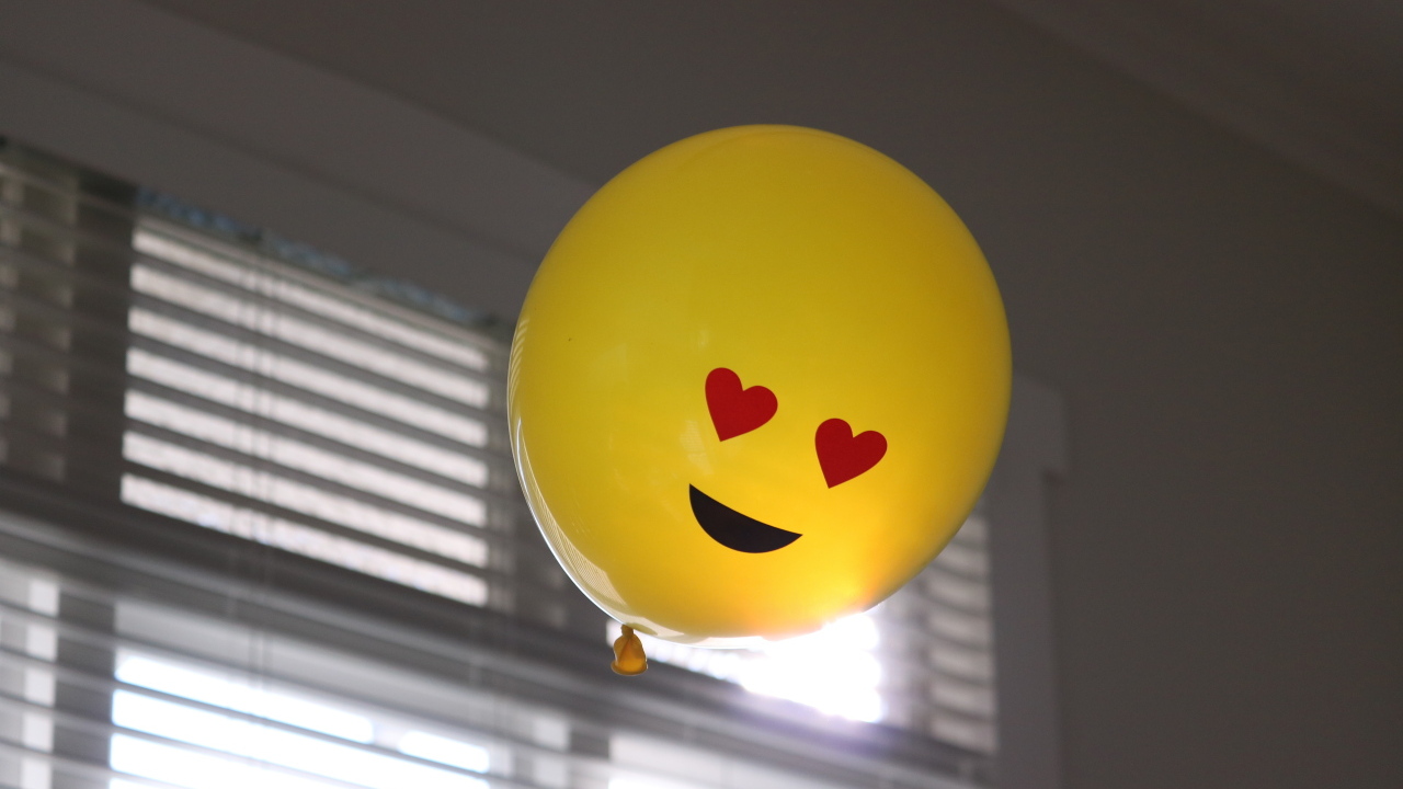 Желтый воздушный шарик с глазами в форме сердца