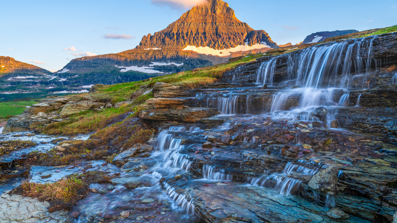 Водопад стекает по камням у высокой горы