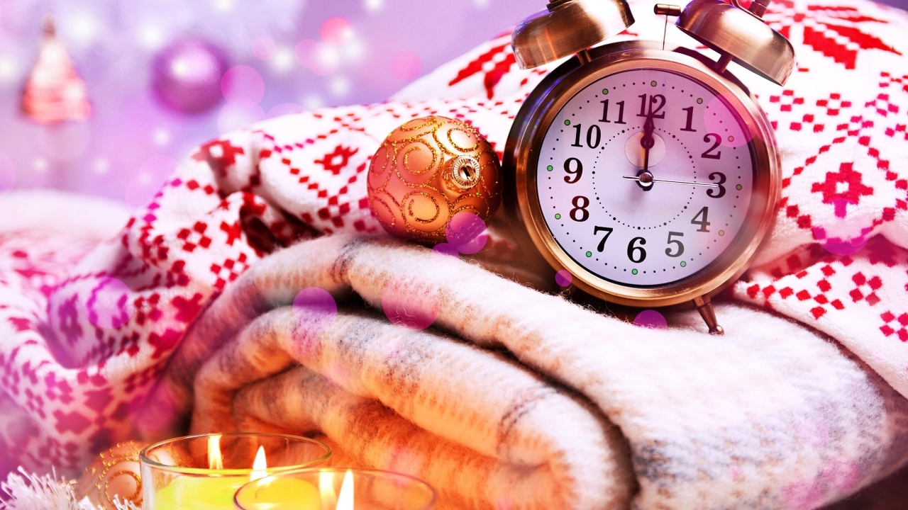 Будильник, теплый плед и зажженные свечи на праздник