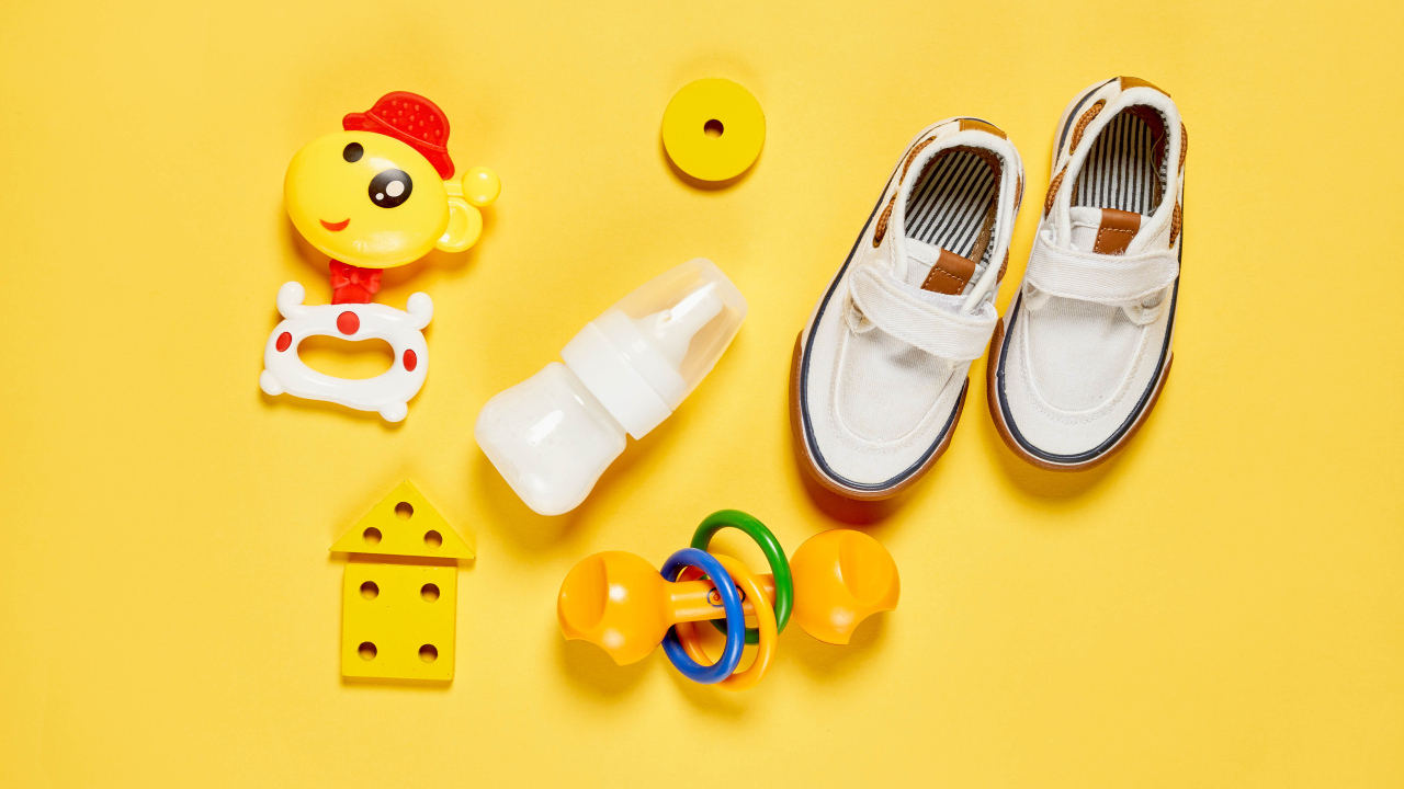 Детские игрушки и обувь на желтом фоне