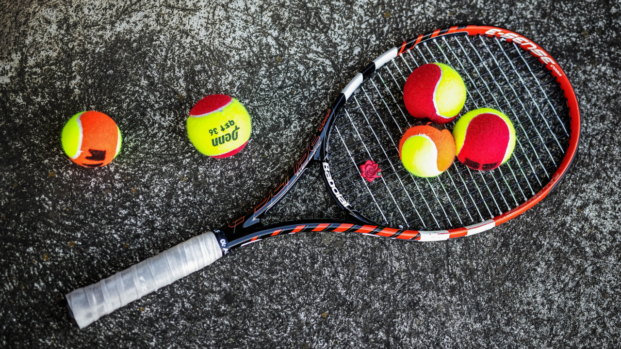 Ракетка и теннисные мячи на черном фоне