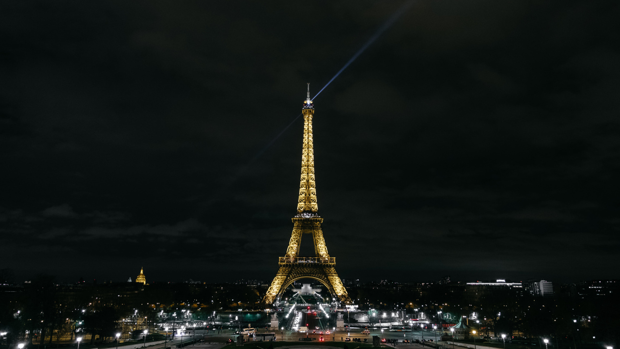 Высокая Эйфелева башня светит огнями ночью, Франция