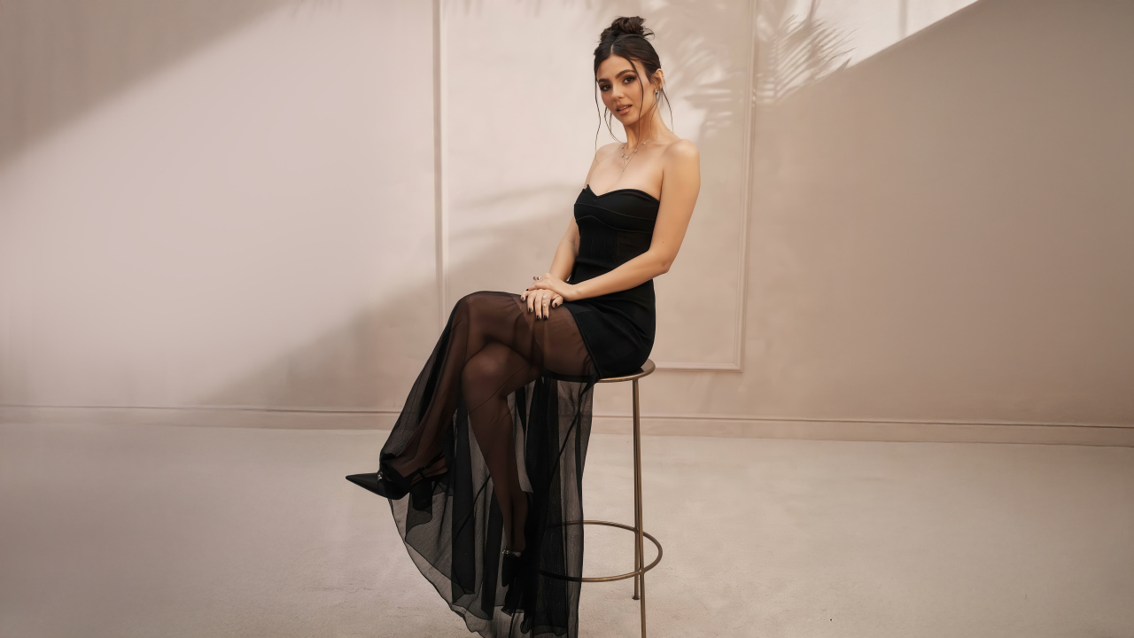 Американская актриса Виктория Джастис в черном платье на стуле