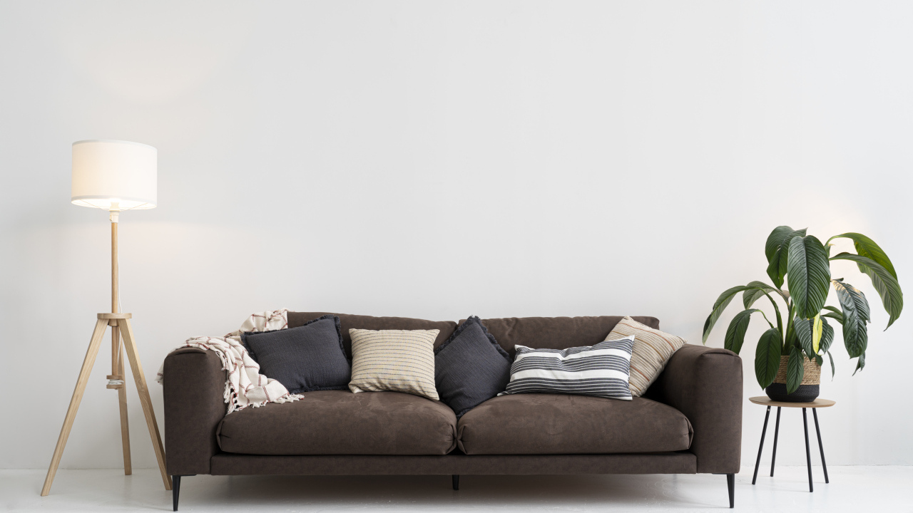 Коричневый диван у серой стены с лампой