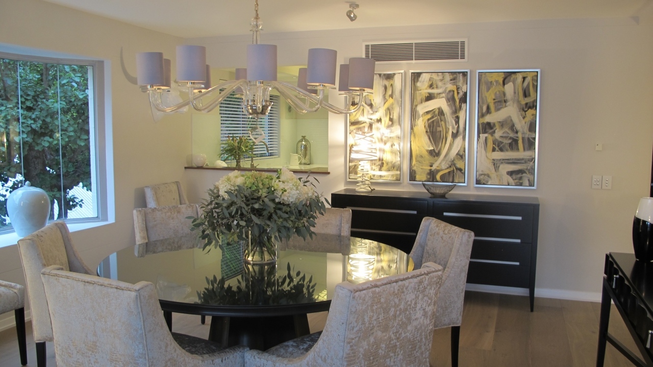 Большой стол со стульями в столовой с большой люстрой