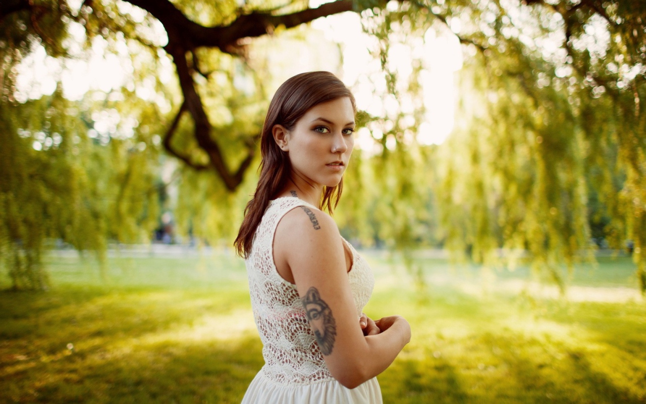 Брюнетка с татуировкой на природе