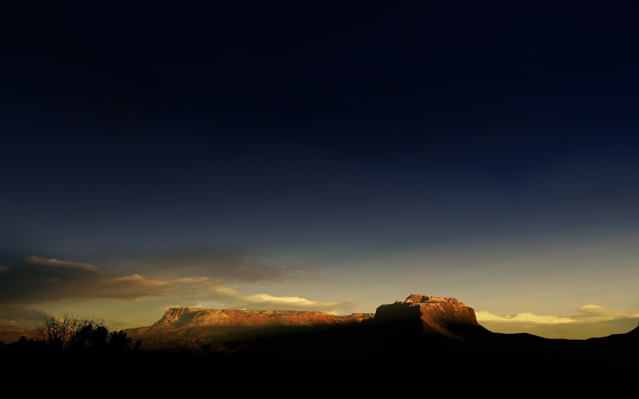 Солнце на закате освещает гору