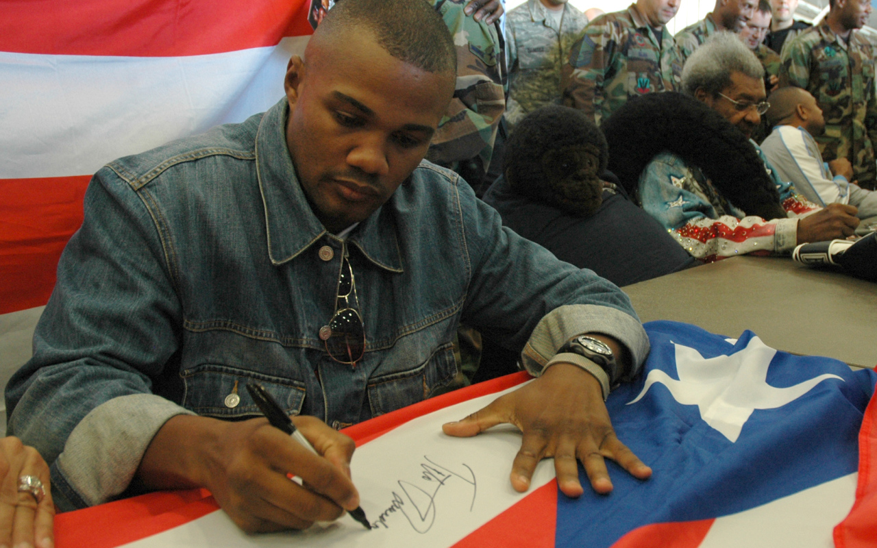 Boxer Felix Trinidad is signing the flag