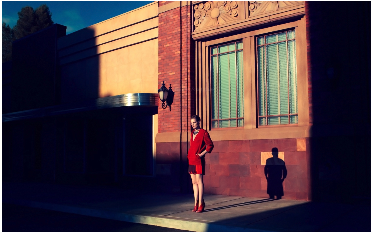 Фотография девушки в красном на фоне здания