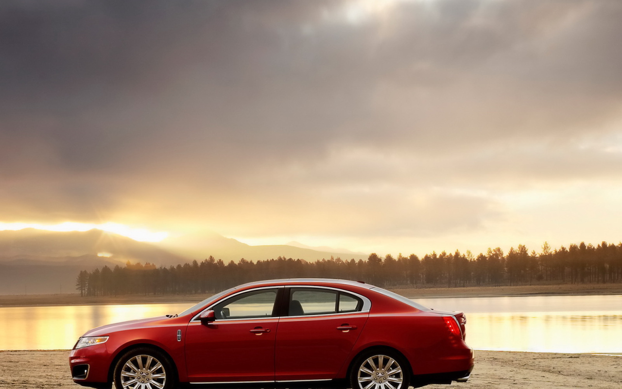 Красный автомобиль на берегу реки