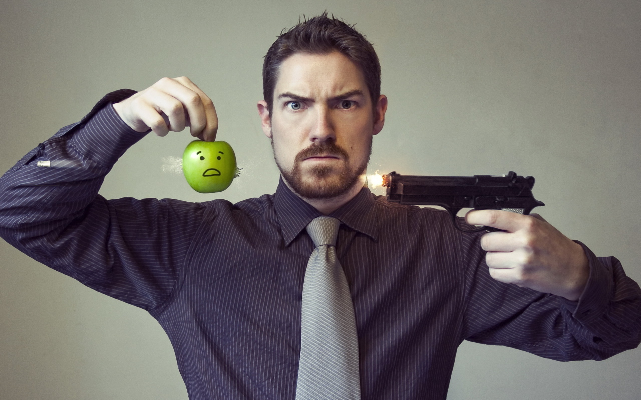 Мужчина стреляет в яблоко