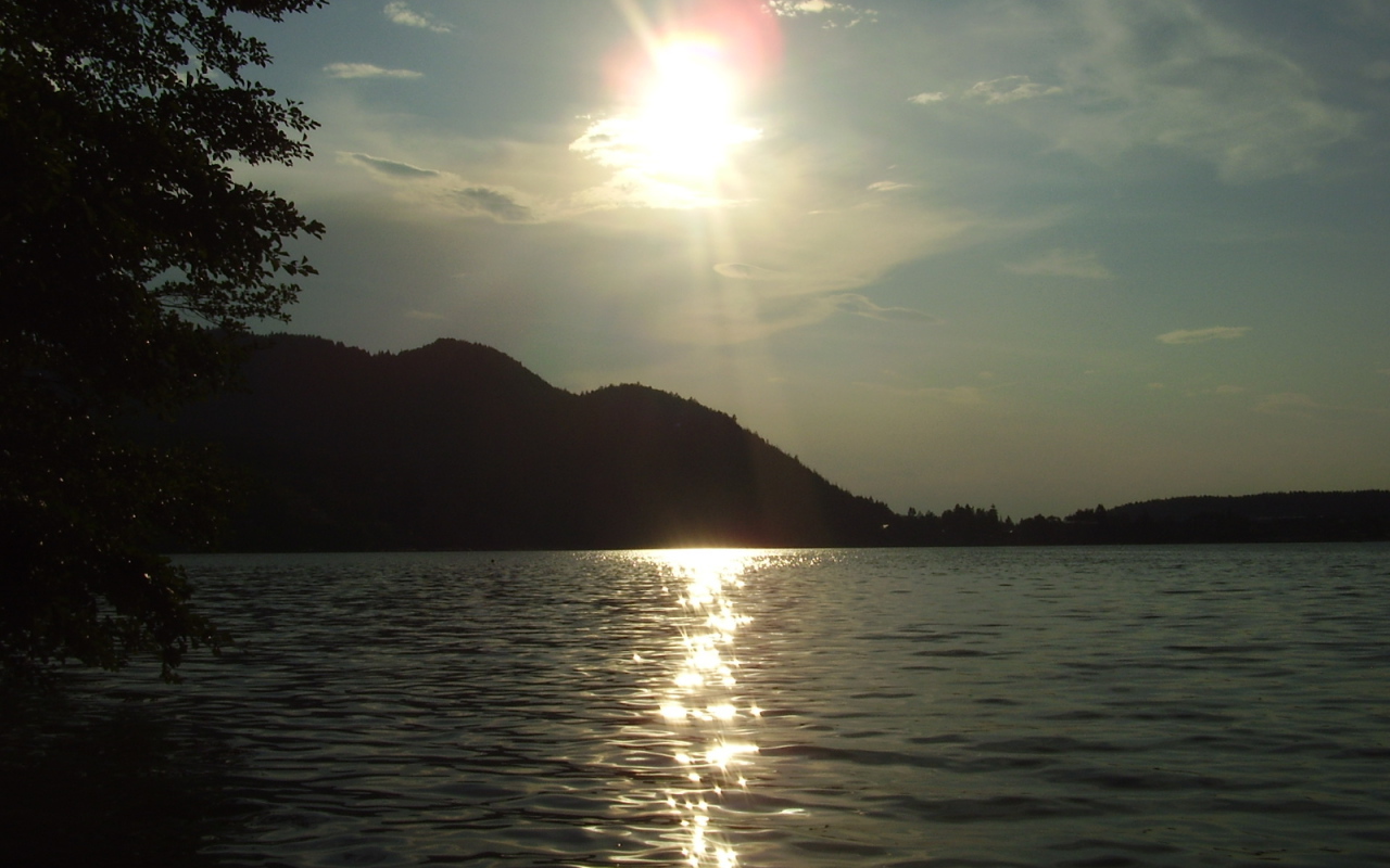 Солнце над водой озера Клопайнер Зее, Австрия