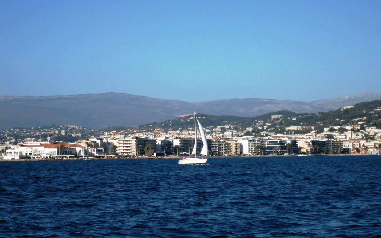 Яхта на фоне города на курорте Порт Де Фрежюс, Франция