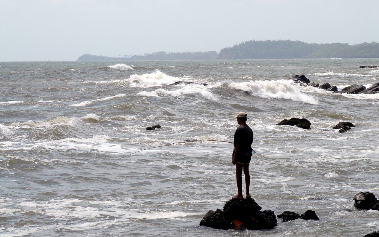 Мужчина ловит рыбу в Гоа