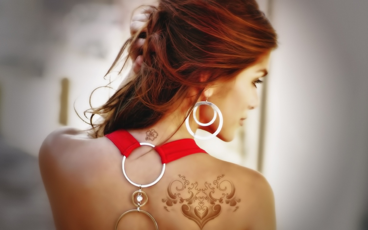 Девушка с татуировками на плече и шее