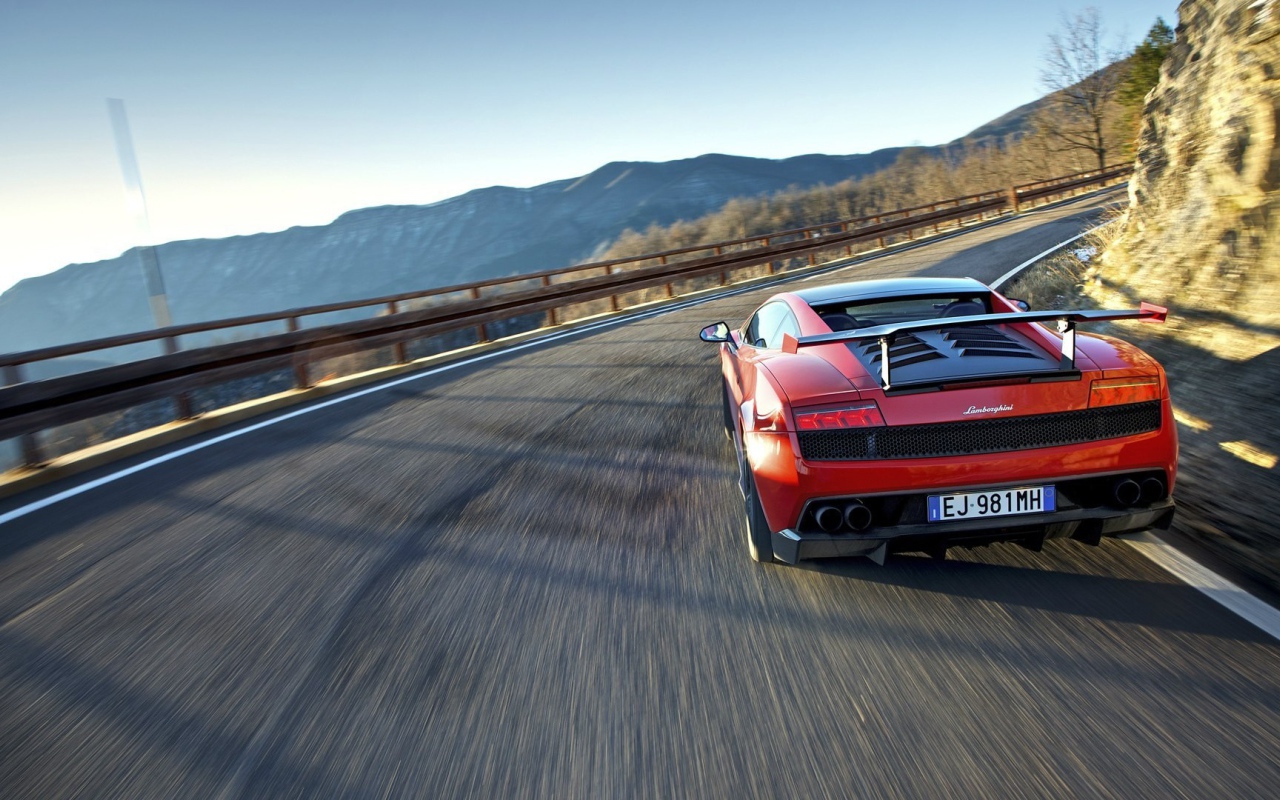 Красный гоночный автомобиль на горной дороге