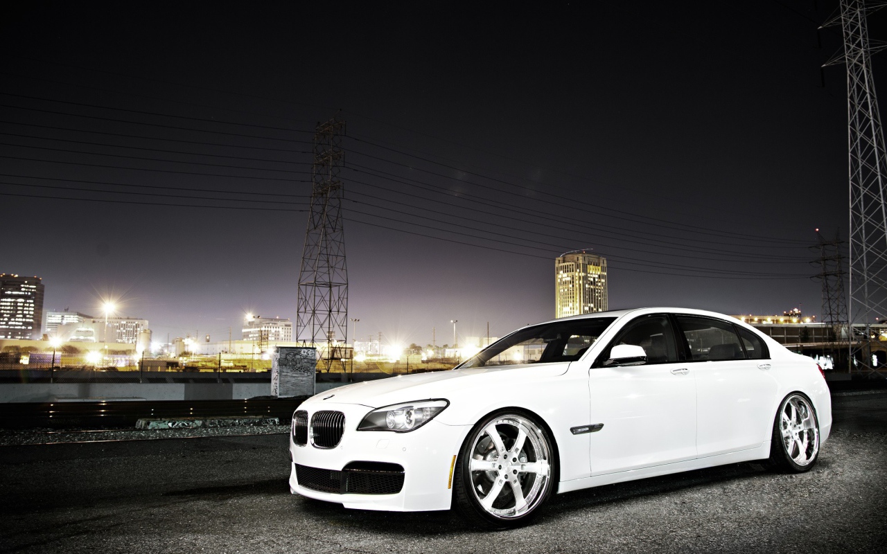 Белый БМВ на фоне ночного города